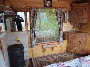 Un hombre toma una fotografía de una habitación en una casa pequeña. en Remote Tiny House Retreat, en Rimetea
