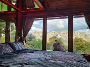 Una pareja parada frente a una ventana en un dormitorio. en Remote Tiny House Retreat, en Rimetea 57 fotos más