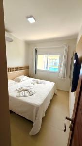 ein Schlafzimmer mit einem weißen Bett und einem Fenster in der Unterkunft Condomínio Boas vistas in Aracati + 20 Fotos