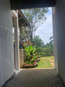 an open door to a courtyard with plants at AJA Homestay in Pronojiwo