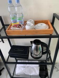a shelf with a tea kettle and water bottles on it at AJA Homestay in Pronojiwo +16 photos