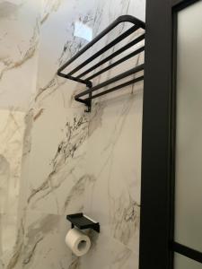 a bathroom with a marble wall with a roll of toilet paper at AJA Homestay in Pronojiwo