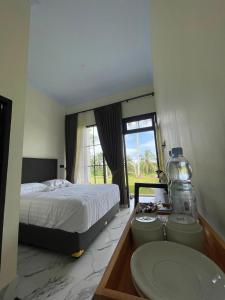 a bedroom with a bed and a sink and a window at AJA Homestay in Pronojiwo