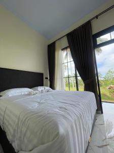 a bedroom with a large bed with a large window at AJA Homestay in Pronojiwo
