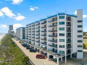 an apartment building at the beach with a parking lot at AquaVista Beach Resort by Panhandle Getaways in Panama City Beach