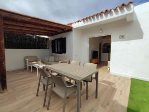 a dining room with a table and chairs at Bungalow con jardín privado junto al Yumbo in Playa del Ingles