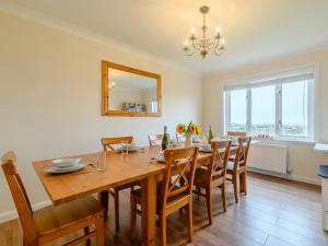 a dining room with a table and chairs and a mirror at Seaglass House in Beadnell