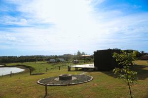 a park with a pond and a building in a field at Casa de Ferro 287 Aconchego e Praticidade in Venâncio Aires