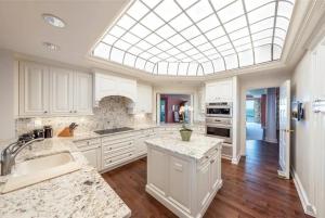 a kitchen with white cabinets and a skylight at Spacious Gulf-view Residence in Naples