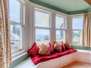 a window seat with pillows in a bay window at The Marle in Belper