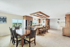 a kitchen and dining room with a wooden table and chairs at Beachfront Three Bedroom Condo with Ocean Views in Venice