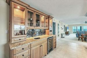 a large kitchen with wooden cabinets and a dining room at Beachfront Three Bedroom Condo with Ocean Views in Venice