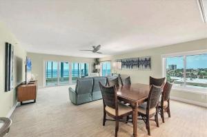 a dining room with a table and chairs and a couch at Beachfront Three Bedroom Condo with Ocean Views in Venice