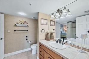 a bathroom with a sink and a toilet and a mirror at Beachfront Three Bedroom Condo with Ocean Views in Venice +2 photos