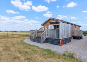 BabcaryにあるLarkrise Farm Lodgesのポーチとオレンジ色のタイヤが付いた小さな小屋 +12枚の写真