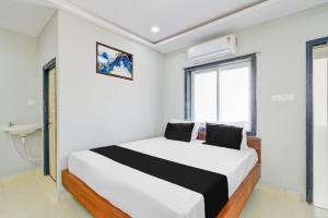 a bedroom with a white bed and a window at Hotel O SSR Grand in Surūrnagar