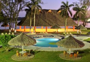 a resort with a swimming pool with straw umbrellas at Hotel Terranova in Coatzacoalcos