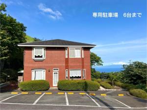 a red brick building with a parking lot at 風薫る宿 伊豆星の舞 in Ito