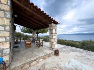 a stone house with a patio with a view of the water at SIX INDEPENDENT HOUSES BY THE sea in Glífa
