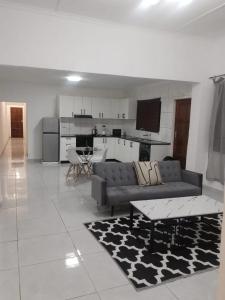 una sala de estar con un sofá y una mesa en Lemon Lodge, en Parow