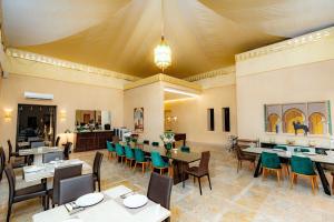 a restaurant with tables and chairs in a room at Palais Nouhass in Marrakech