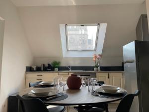 a kitchen with a table with chairs and a refrigerator at Vue Cathedrale, Elegance & Lumière à Amiens in Amiens