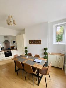 eine Küche und ein Esszimmer mit Tisch und Stühlen in der Unterkunft Northcliffe - Stylish Stone Cottage - Spa Bath - Peak Views in Bradwell