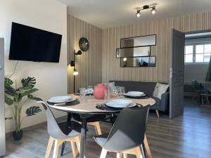 a dining table and chairs in a living room at Vue Cathedrale, Elegance & Lumière à Amiens in Amiens