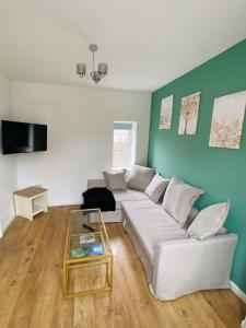 ein Wohnzimmer mit einer weißen Couch und einem Glastisch in der Unterkunft Northcliffe - Stylish Stone Cottage - Spa Bath - Peak Views in Bradwell + 16 Fotos