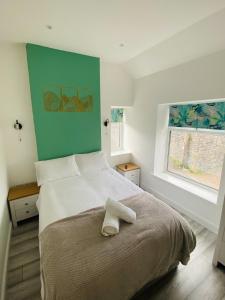 ein Schlafzimmer mit einem Bett und einem Handtuch darauf in der Unterkunft Northcliffe - Stylish Stone Cottage - Spa Bath - Peak Views in Bradwell