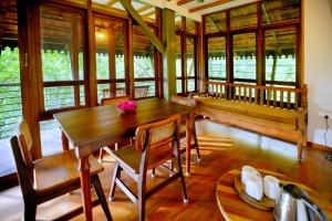 une salle à manger avec une table et des chaises en bois dans l'établissement Solitude Munnar - Tree house, à Munnar
