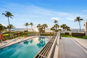 a swimming pool with a view of the beach at Gulf-front Masterpiece in Naples