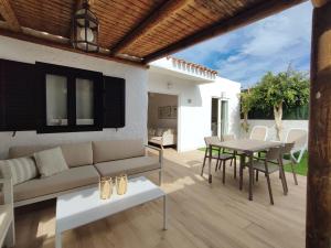 a patio with a couch and a table and chairs at Bungalow con jardín privado junto al Yumbo in Playa del Ingles