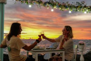 two women sitting at a table with a glass of wine at Respect Homestay Phu Quoc in Phu Quoc +38 photos