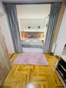 a bedroom with a large bed and wooden floors at Apartment Irma in Sarajevo
