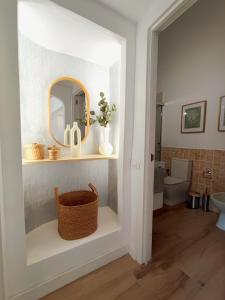 a bathroom with a mirror and a basket on a shelf at Bungalow con jardín privado junto al Yumbo in Playa del Ingles