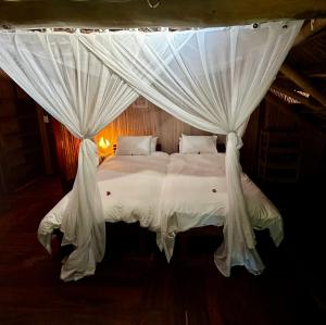 a bedroom with a white bed with a canopy at Ebony Beach in Vilanculos +53 photos