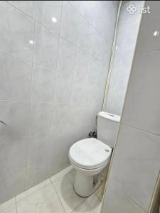 a bathroom with a toilet in a tiled room at Apartment in Republic Square in Yerevan