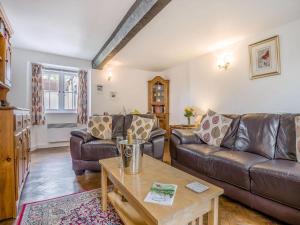 a living room with leather couches and a coffee table at Horseshoe Cottage-Uk37360 in Lympsham