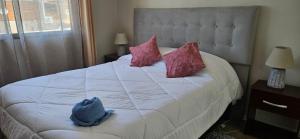 a bedroom with a large white bed with pink pillows at Habitacion Matrimonial privada en machali con parcking y wifi in Rancagua +2 photos