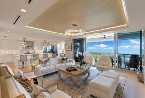 a living room with white furniture and a kitchen at Smart-home & Panoramic Water Views in Naples