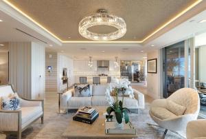 a living room with white furniture and a chandelier at Smart-home & Panoramic Water Views in Naples