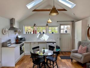 a kitchen and living room with a table and chairs at The Cottage in Bristol