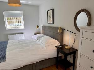 Schlafzimmer mit einem Bett mit einem Spiegel und einem Tisch in der Unterkunft The Cottage in Bristol