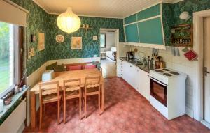 a kitchen with a wooden table and a dining room at Gorgeous Home In Örkelljunga With Wifi in Orkelljunga