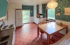 a kitchen with a wooden table and a dining room at Gorgeous Home In Örkelljunga With Wifi in Orkelljunga