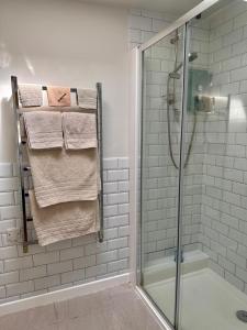 ein Badezimmer mit einer Dusche und Handtüchern auf einem Kleiderständer in der Unterkunft The Cottage in Bristol + 9 Fotos