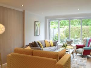 Una sala de estar con un sofá y sillas y ventanas. en Riversdale, en Grasmere