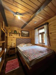 a bedroom with a bed in a wooden cabin at Domek w lesie, nocleg na Lubelszczyźnie in Sosnówka