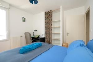 a bedroom with a blue bed and a desk at La loge du Minotaure, parking et bureaux in Toulouse +38 photos